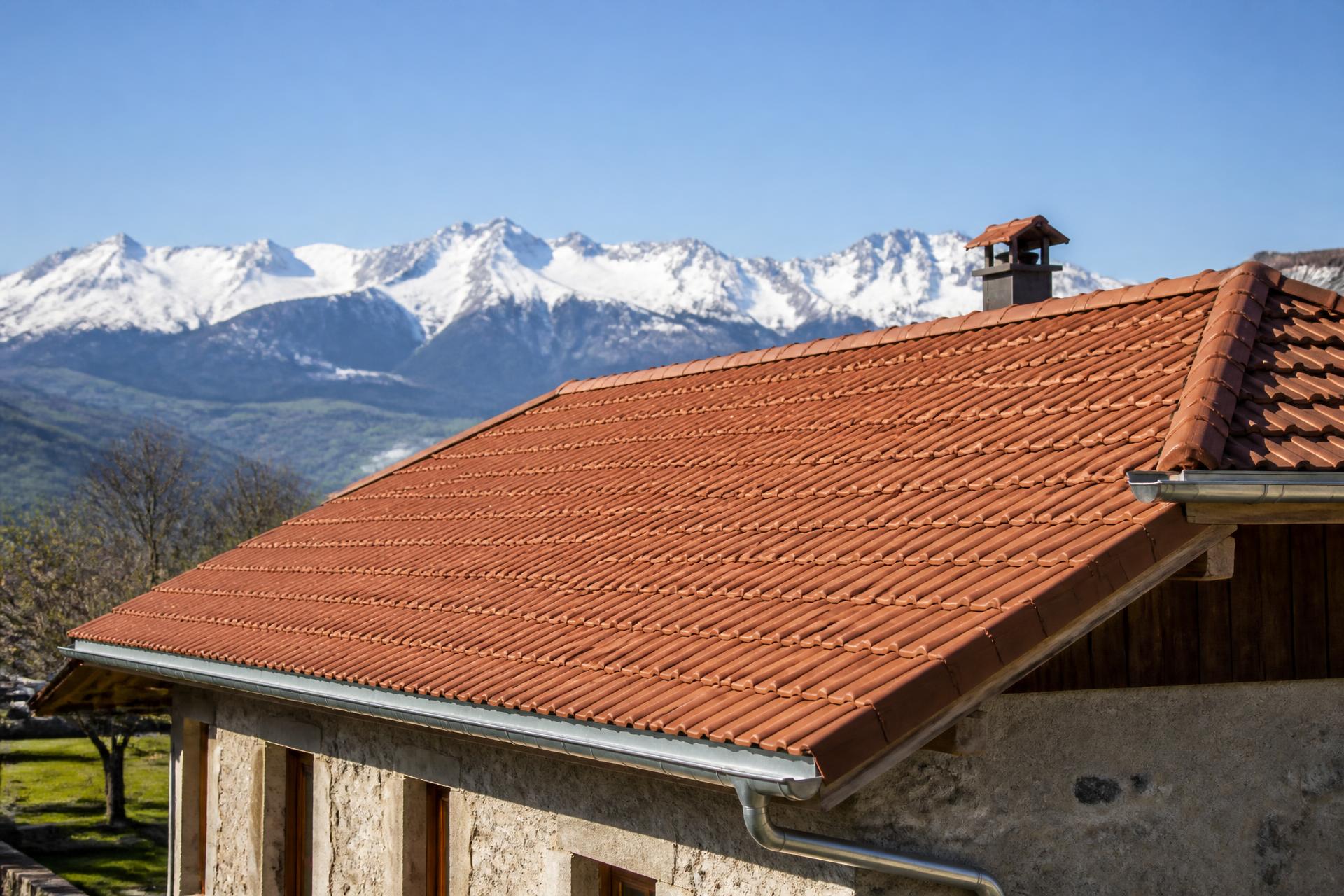 Toiture en tuiles rénovée en Savoie face aux montagnes enneigées